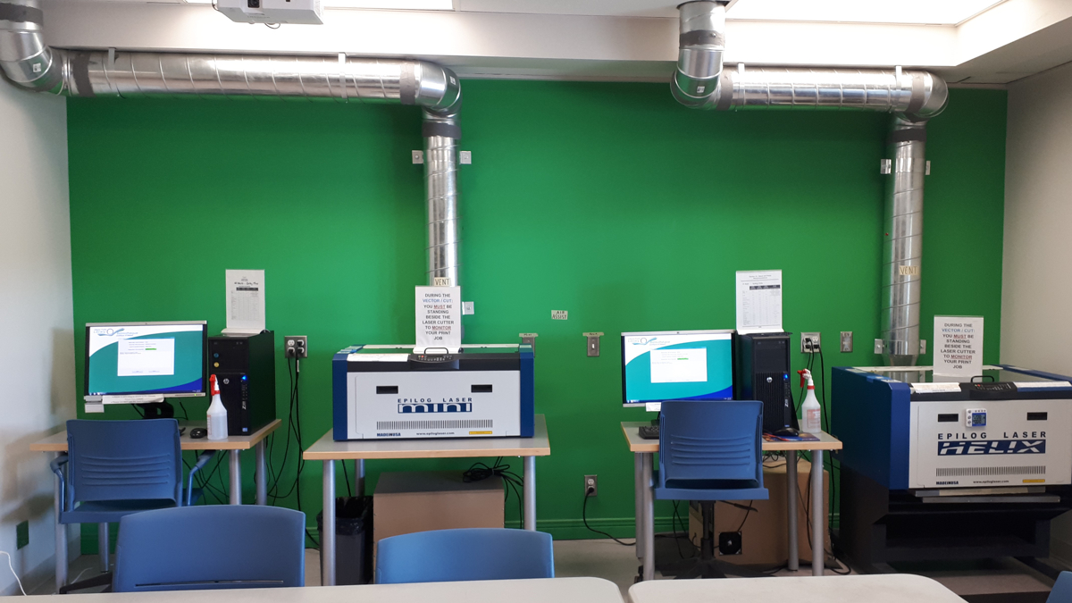View of Imagine Space wall with two laser cutters and green screen